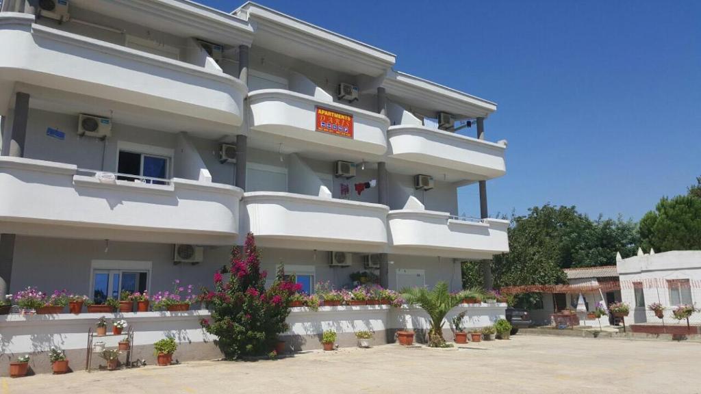 a large white building with flowers in front of it at Apartments Daris in Ulcinj