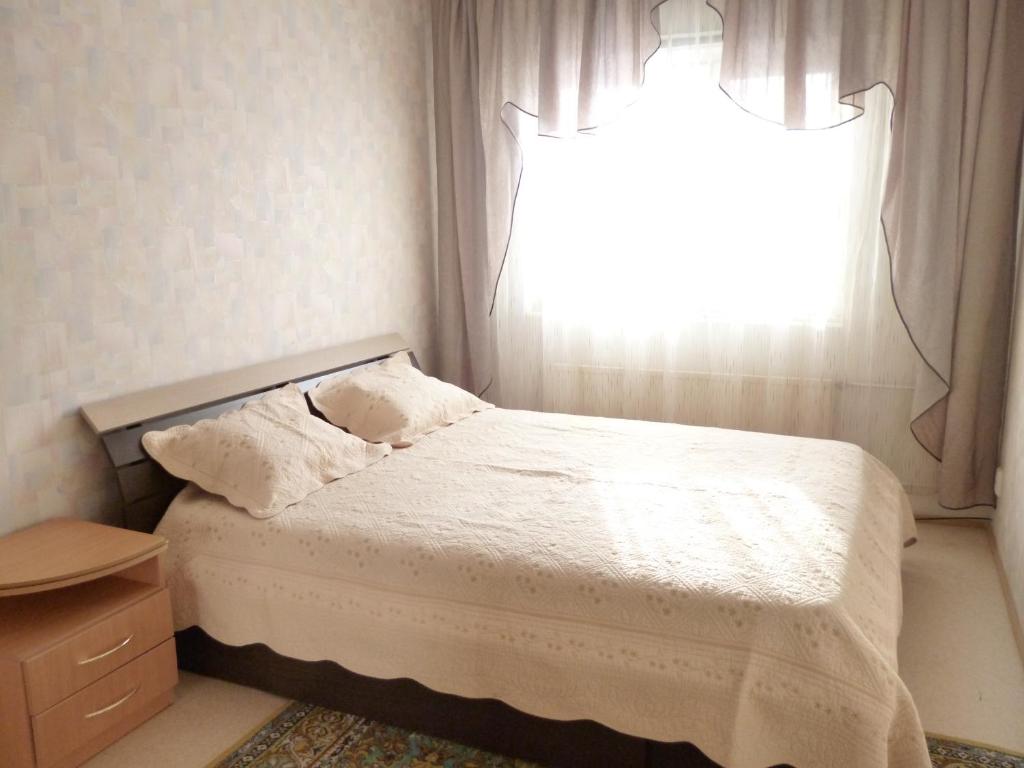 a small bedroom with a bed with a window at Apartment 6 Mikrorayon in Kurgan