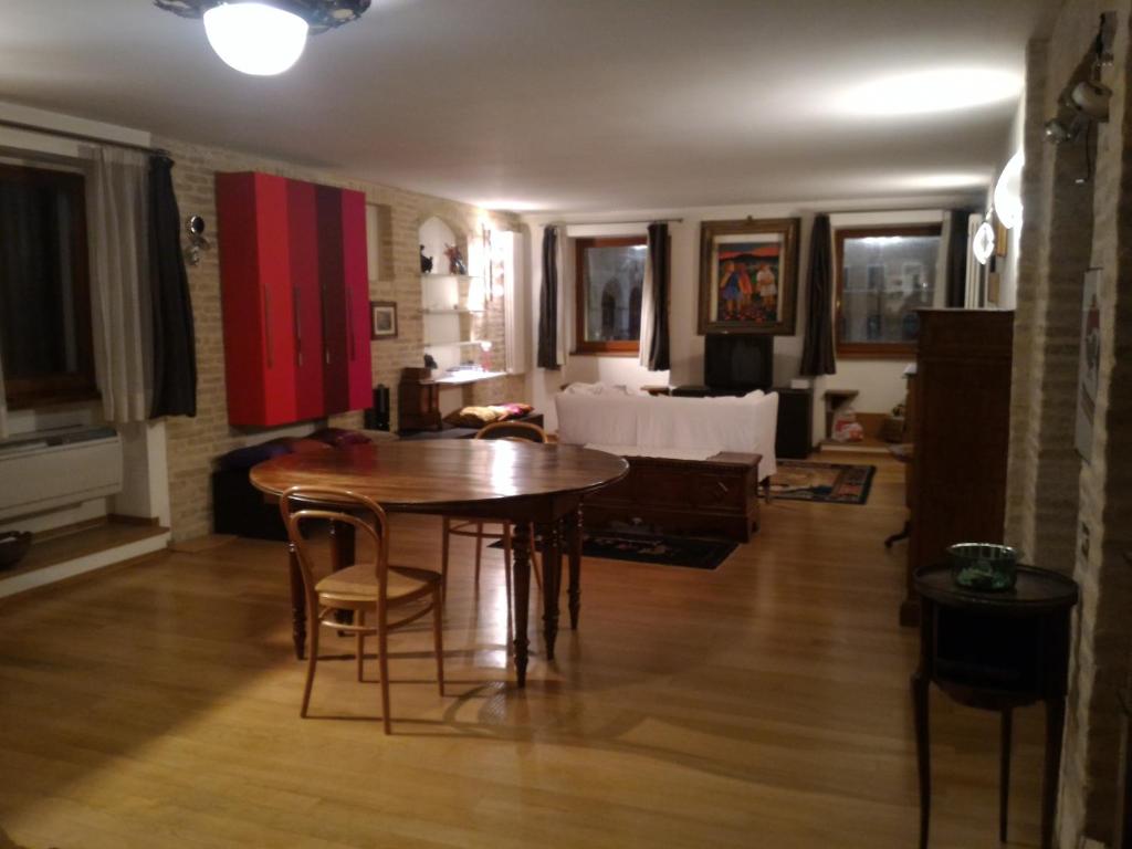 sala de estar con mesa de madera y sillas en La dea Fortuna, en Fano