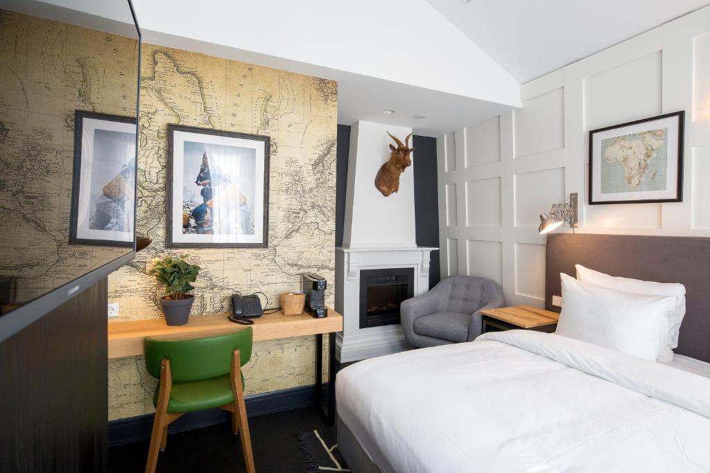 
a bedroom with a bed, a desk and a painting on the wall at The Highland House in Amsterdam
