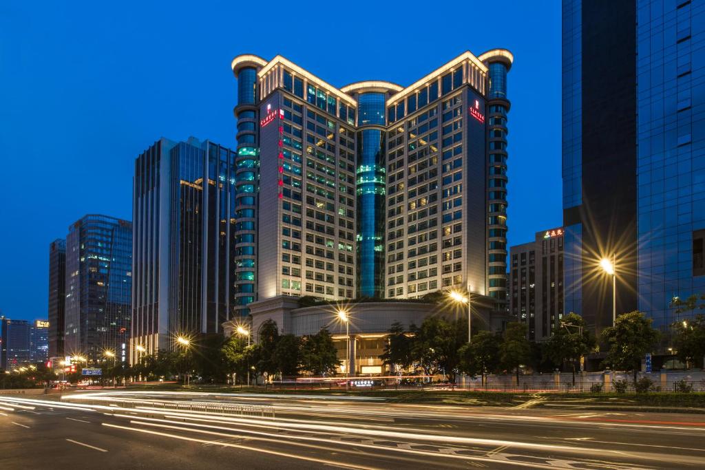 een hoog gebouw met lichten in de stad 's nachts bij Vanburgh Hotel - Free shuttle bus transfer during Canton Fair in Guangzhou