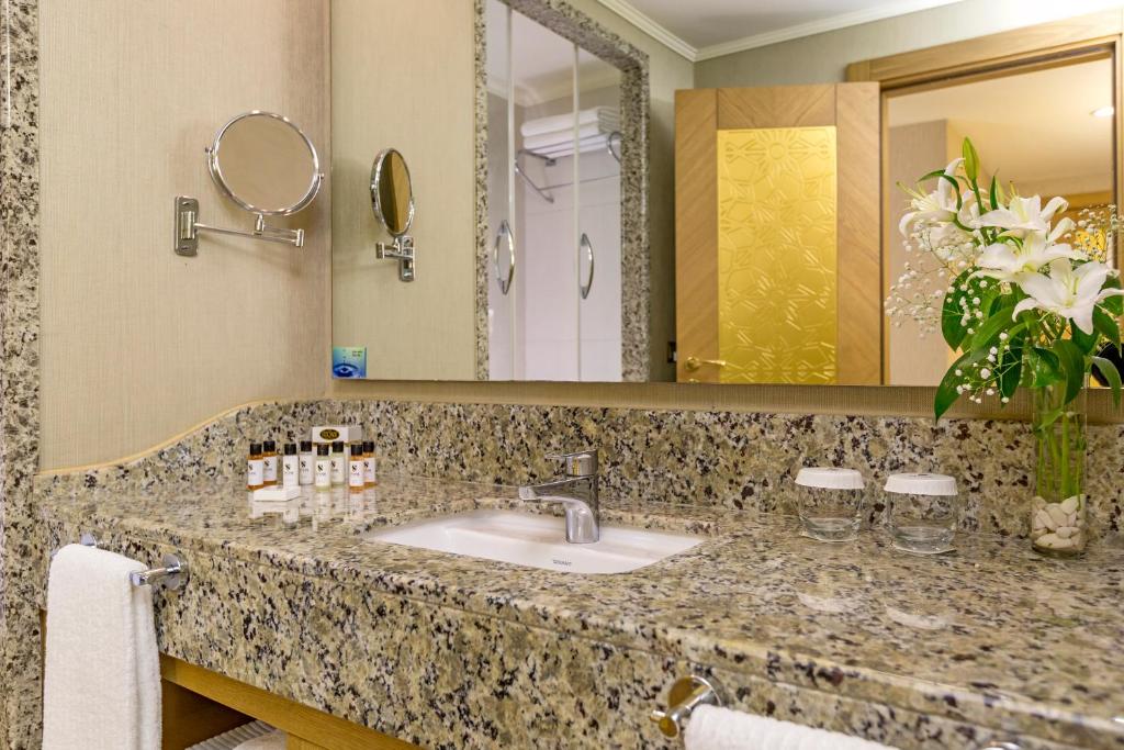 a bathroom with a sink and a mirror at Royal Holiday Palace in Lara