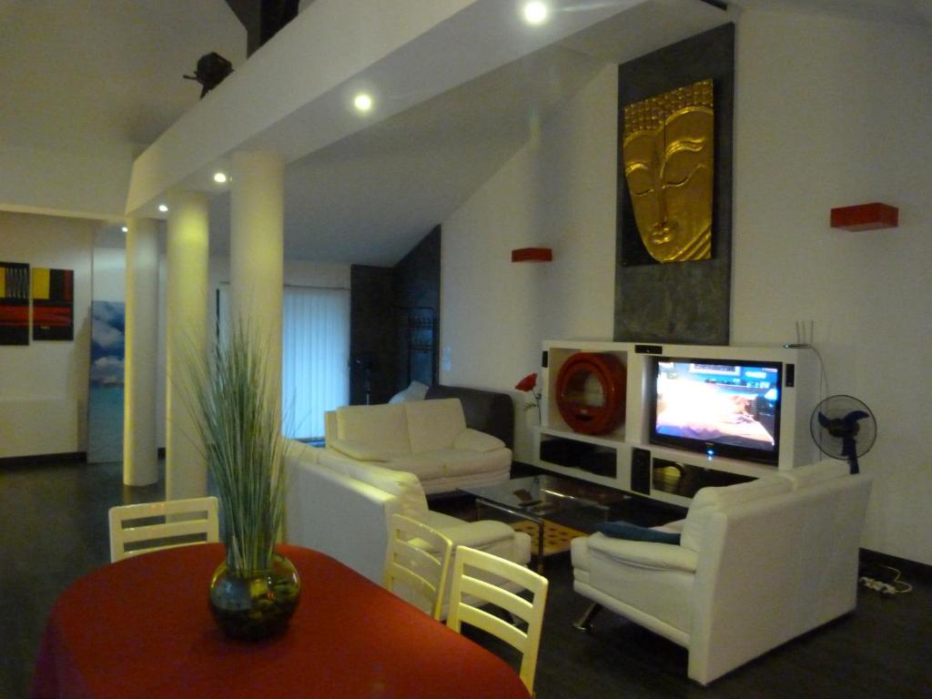 a living room with white furniture and a tv at Holidays in Paris Loft design & atypique avec jardin in Massy