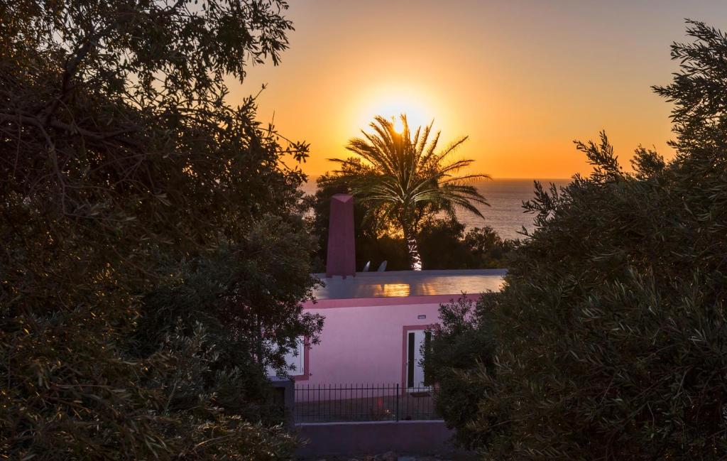 a house with the sunset in the background at Palm Beach House in Sfinárion