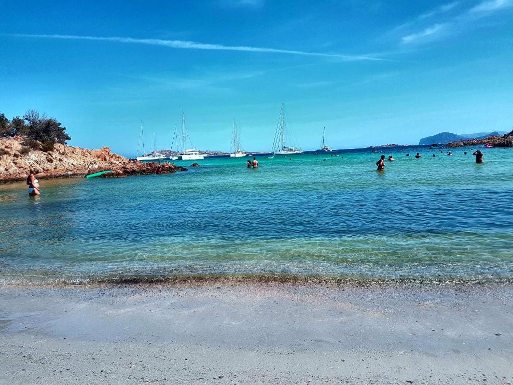 a group of people in the water at a beach at La Casa di Chris in Golfo Aranci