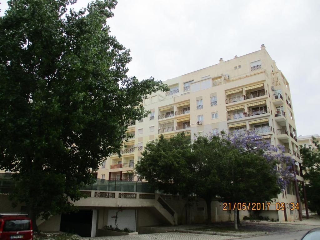 a large white building with trees in front of it at Edificio Canoa in Armação de Pêra