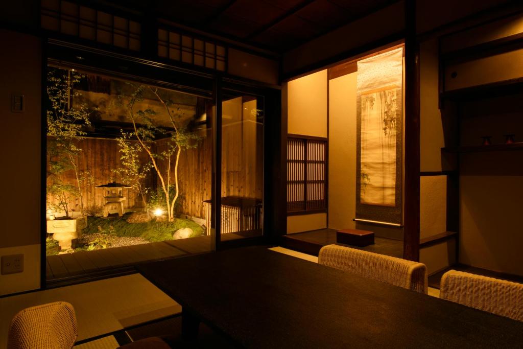 a dining room with a table and a window at Kuraya Jurakudai in Kyoto