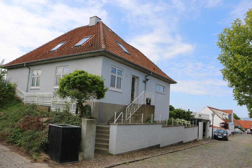 ein weißes Haus mit rotem Dach in der Unterkunft Ebeltoft-rooms in Ebeltoft