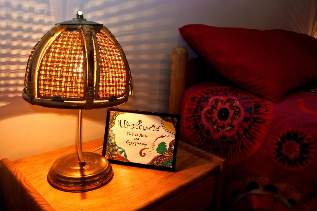a lamp on a table next to a bed at Cozy Beach House in Viana do Castelo