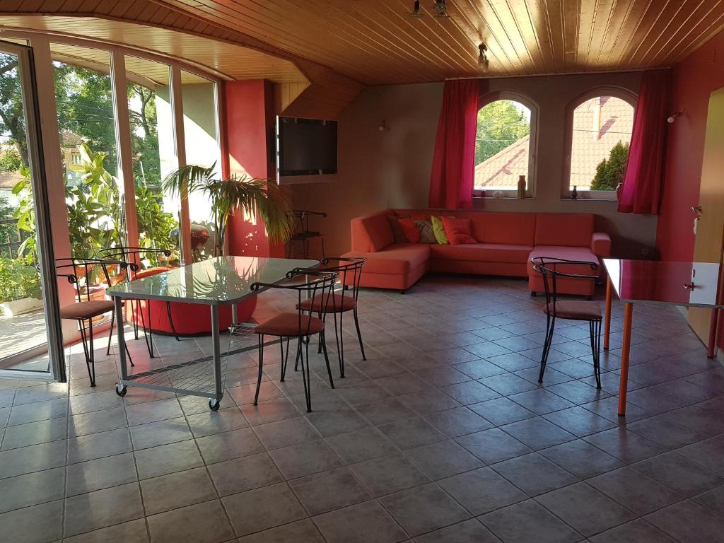 a living room with a couch and a table and chairs at Szigeti Apartmanház in Pécs