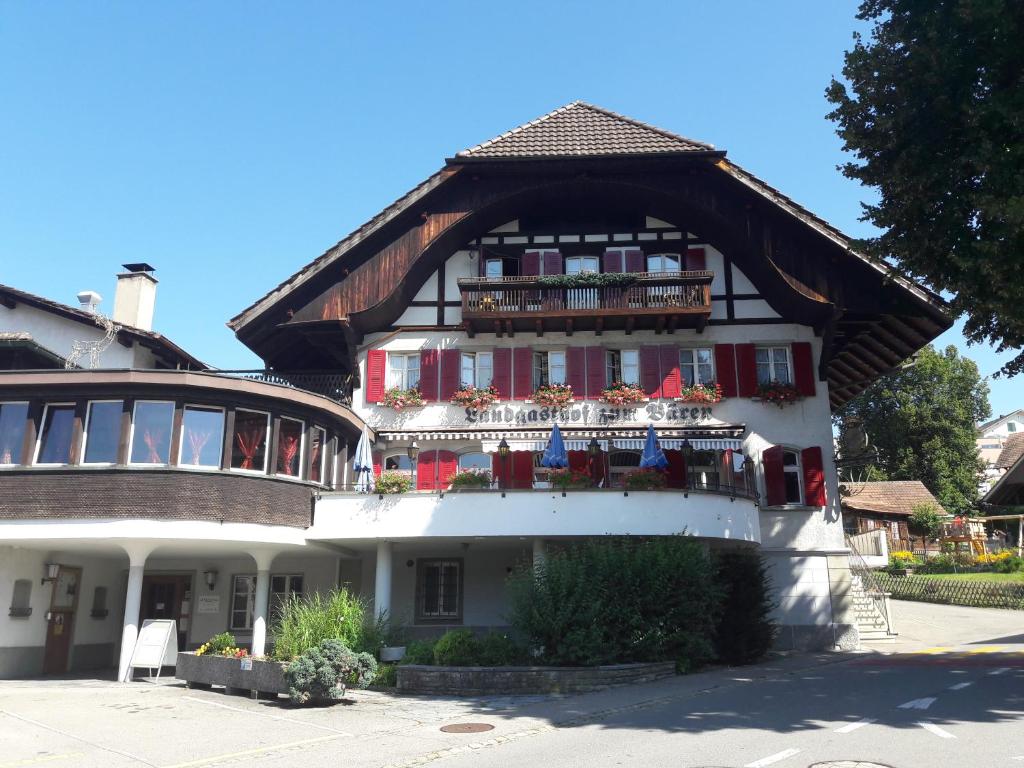 un edificio con un balcón con flores. en Hotel Bären Bern-Neuenegg Self-Check-In, en Neuenegg