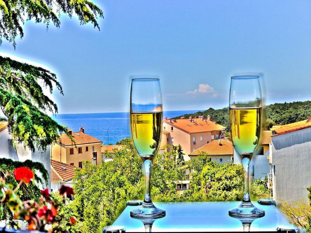 two glasses of white wine sitting on a table at Apartments Andrea in Pula