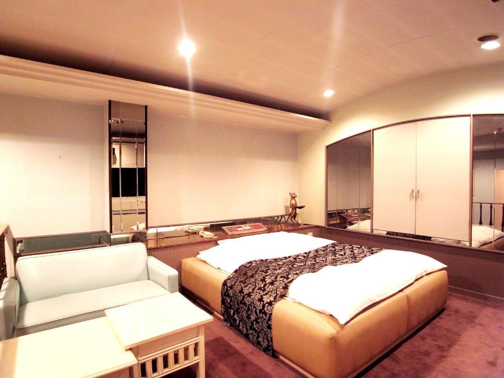 une chambre d'hôtel avec un lit et un canapé dans l'établissement スタンドアップ法隆寺Adult Only男塾ホテルグループ, à Yamatokoriyama