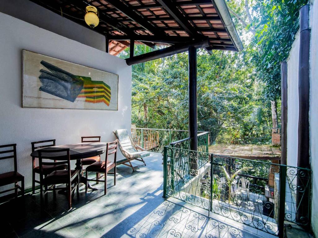 a patio with a table and chairs on a balcony at Ilha House Suítes in Ilhabela