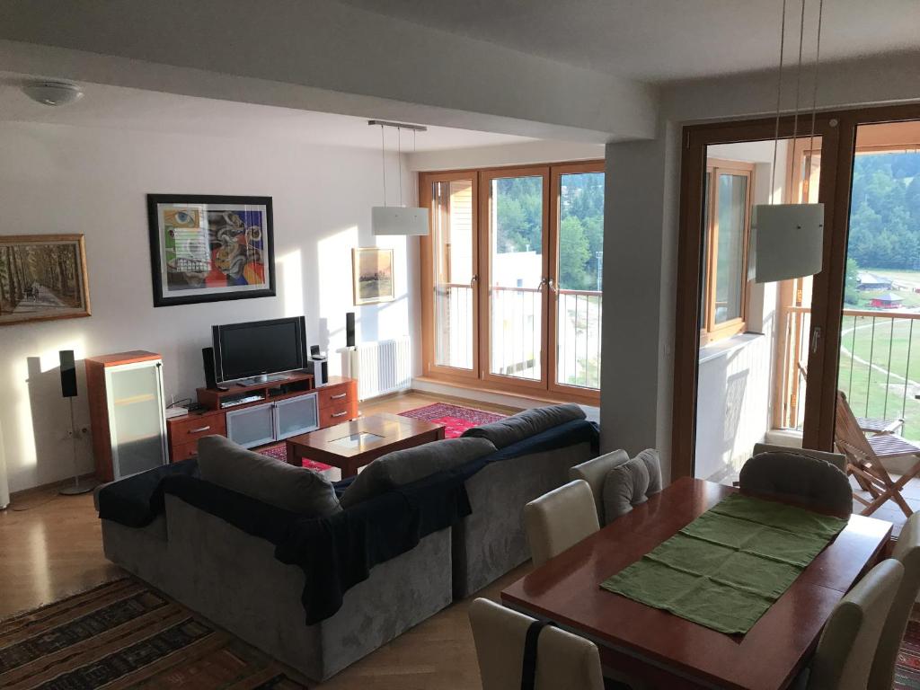 ein Wohnzimmer mit einem Sofa und einem Tisch in der Unterkunft Apartmani El Tarik in Bjelašnica