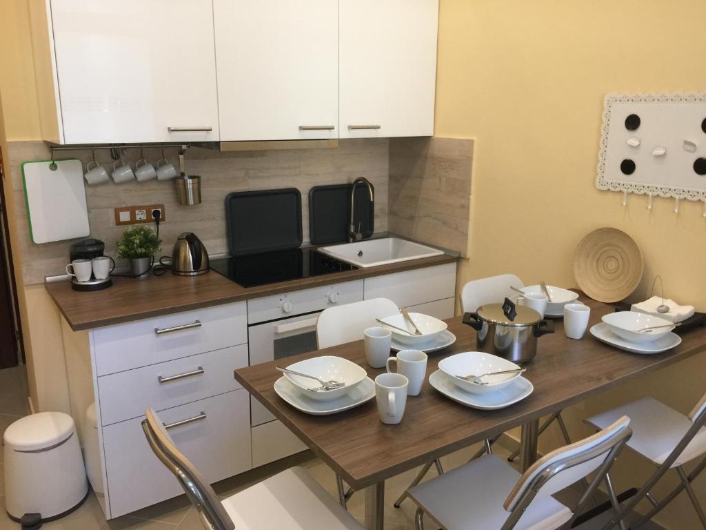 ブダペストにあるEntire luxury apartment in the city centerのキッチン(木製テーブル、白いキャビネット付)