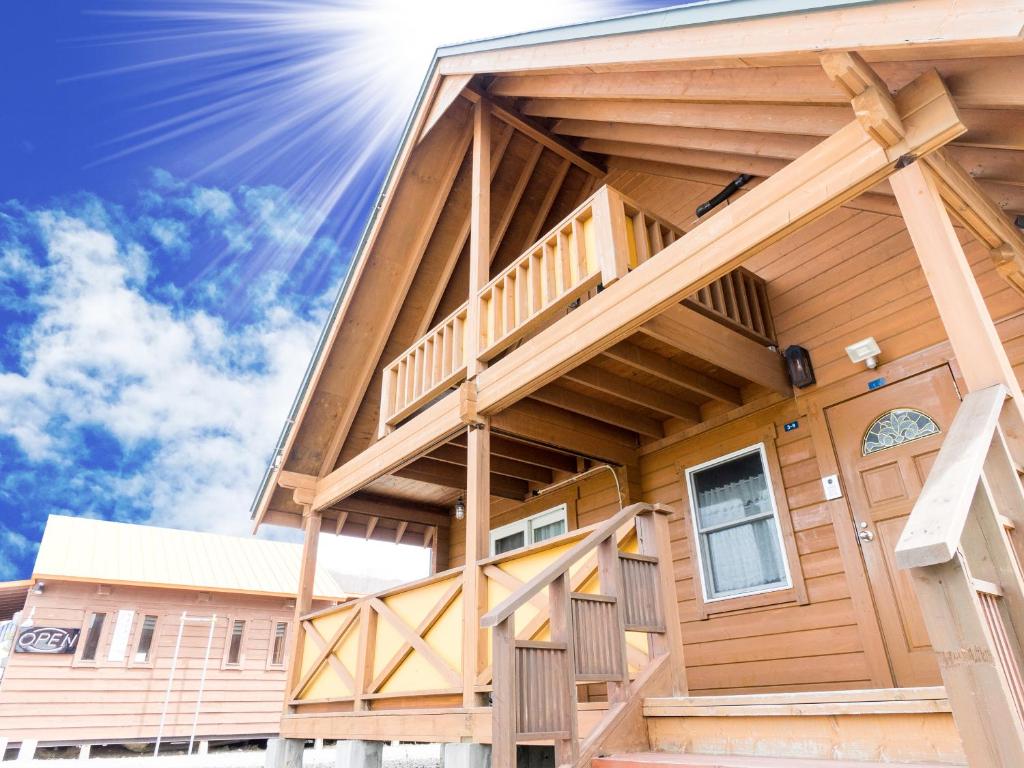 a house with a deck with the sun in the background at Sakura Garden in Otaru