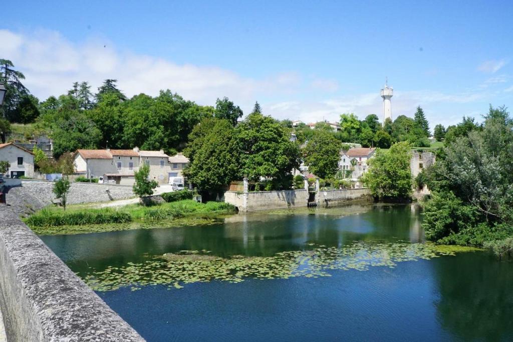 un río con algas en el agua y casas en La Maison Colline en Luxé