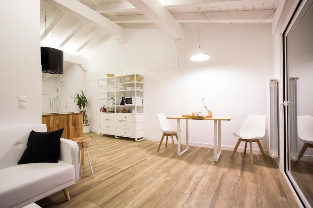 a white living room with a table and chairs at Markulluko Borda Rural Suites in Elizondo