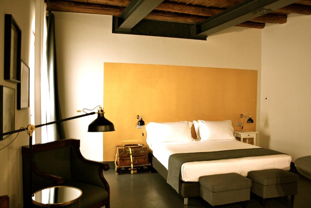 ヴェローナにあるPepita Lodgeのベッドと椅子付きのホテルルーム