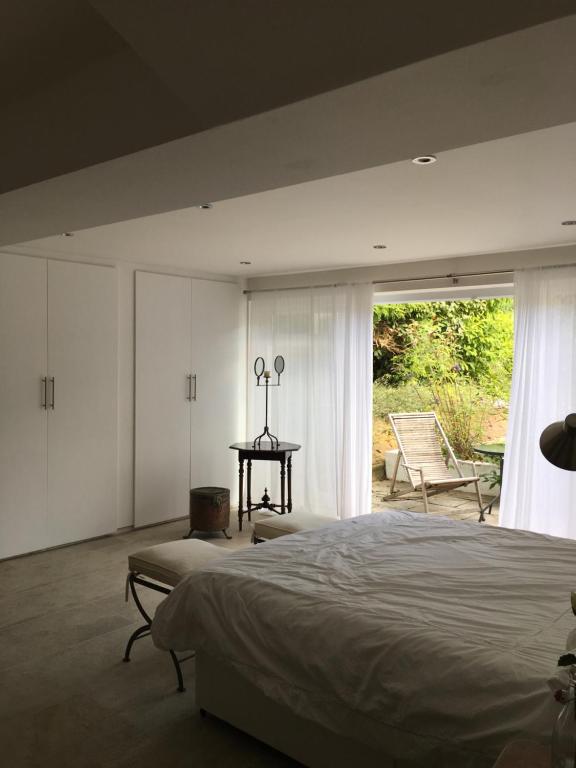 een slaapkamer met een bed, een tafel en een raam bij Private luxury retreat in Sible Hedingham