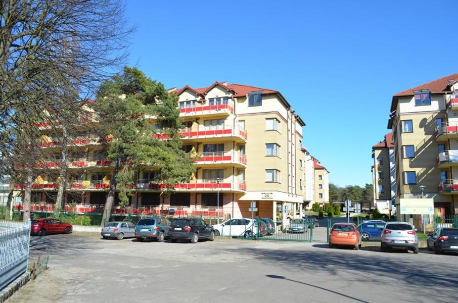 parking z samochodami zaparkowanymi przed budynkiem w obiekcie Apartament Zdrojowa u Heleny w Świnoujściu