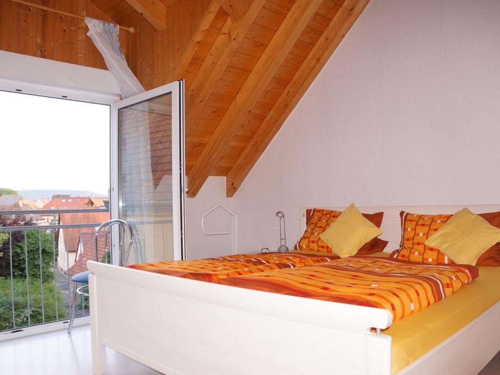 a bed in a room with a large window at Ferienhaus An der Schlossmauer in Oberschwarzach