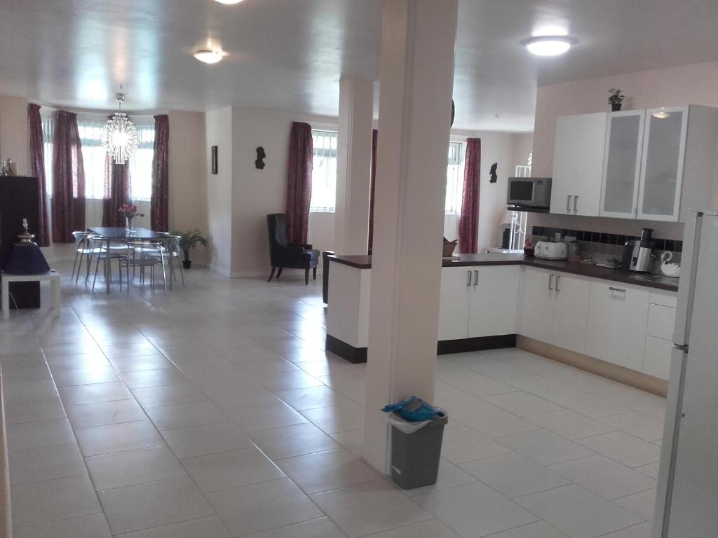 - une cuisine avec des placards blancs, une table et des chaises dans l'établissement Campeche Villa, à Méro