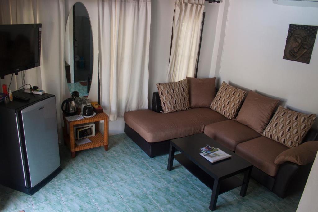 a living room with a couch and a tv at Baan Sawainam Koh Tao in Koh Tao