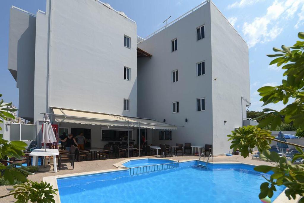 a hotel with a swimming pool in front of a building at Ialysos City Hotel in Ialysos