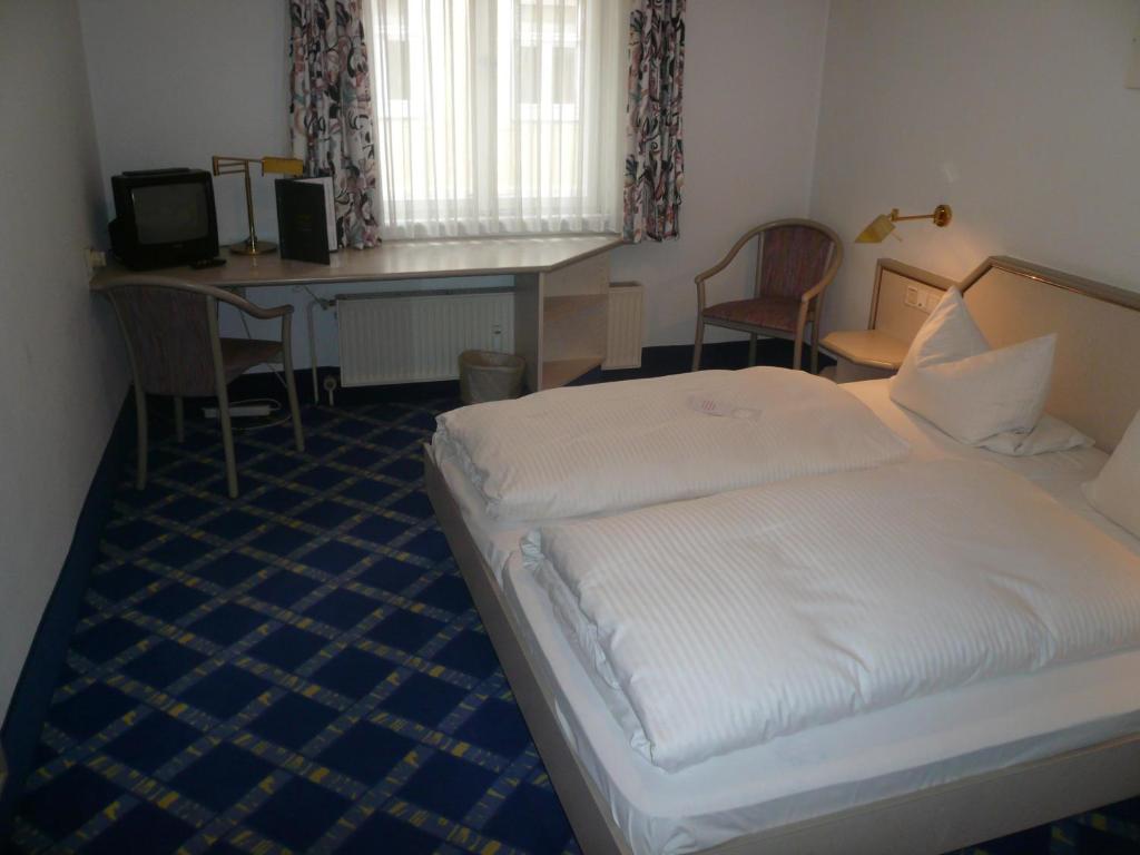 a hotel room with a bed and a desk and chairs at booking Residenz in Coburg