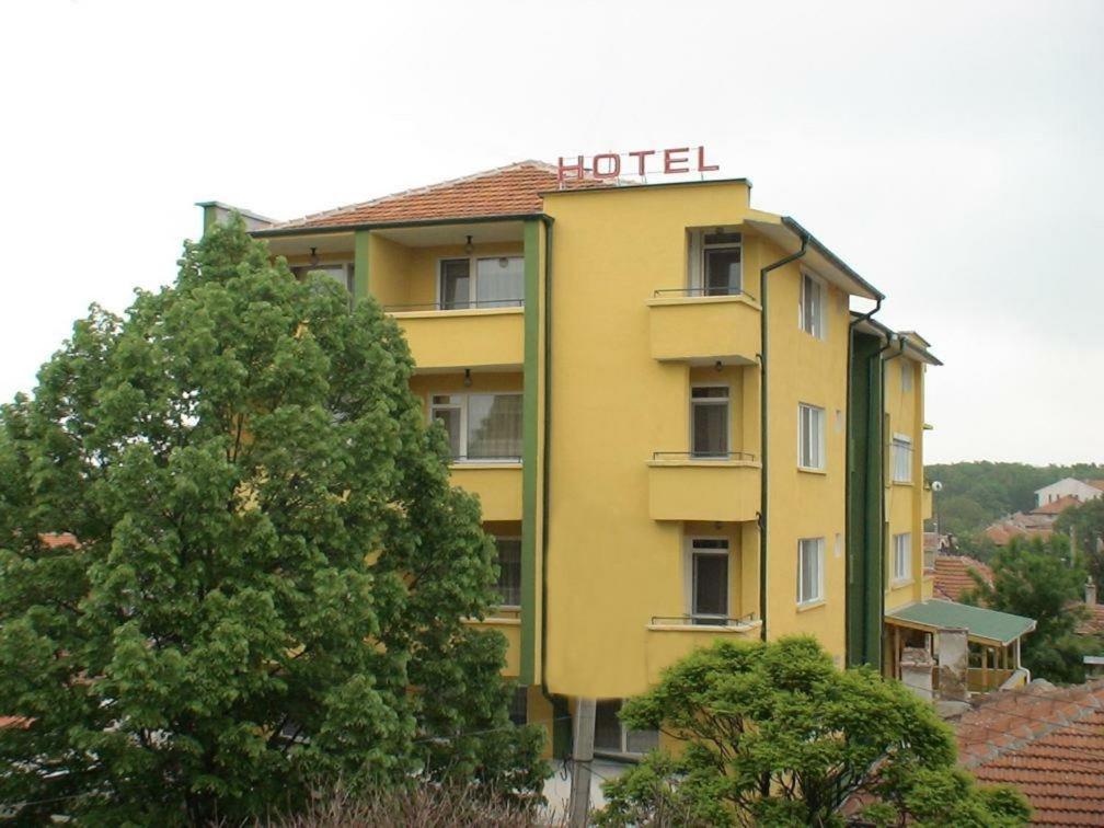 um hotel amarelo com uma placa em cima em Hotel Triumph em Nova Zagora