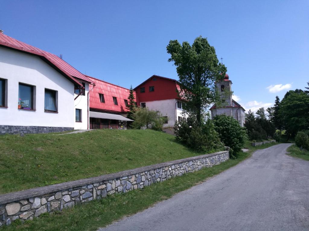 un camino junto a una casa y una pared de piedra en Pension Sport en Malá Morava