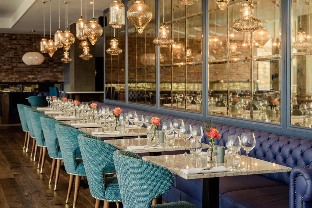 a row of tables in a restaurant with blue chairs at Osprey Hotel in Naas