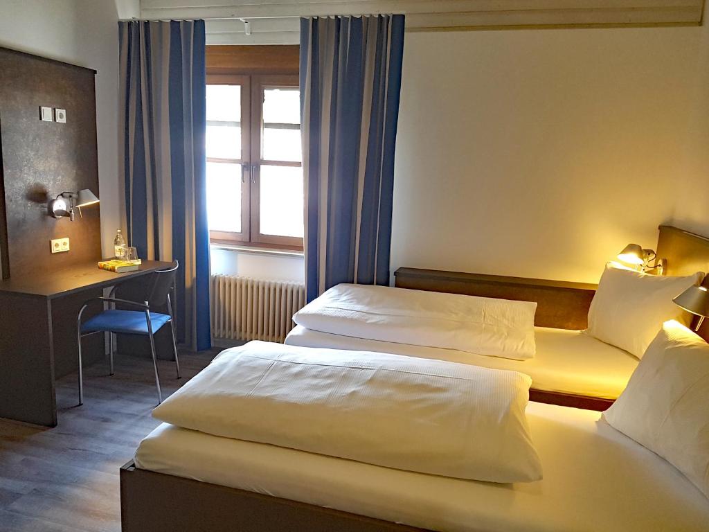 a hotel room with two beds and a desk at Tagungshaus Wernau in Wernau