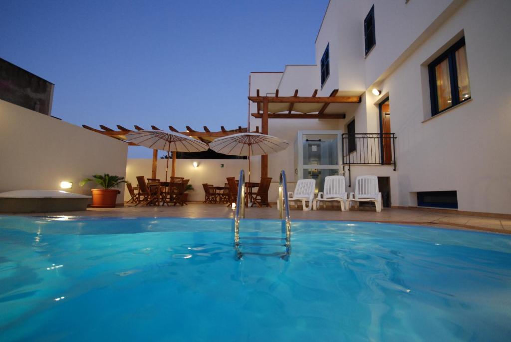 ein Schwimmbad in der Mitte eines Hauses in der Unterkunft Hotel Altamarea in San Vito lo Capo