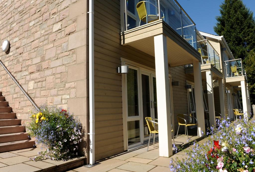 a house with a balcony and a patio at Craigmhor Lodge & Courtyard in Pitlochry