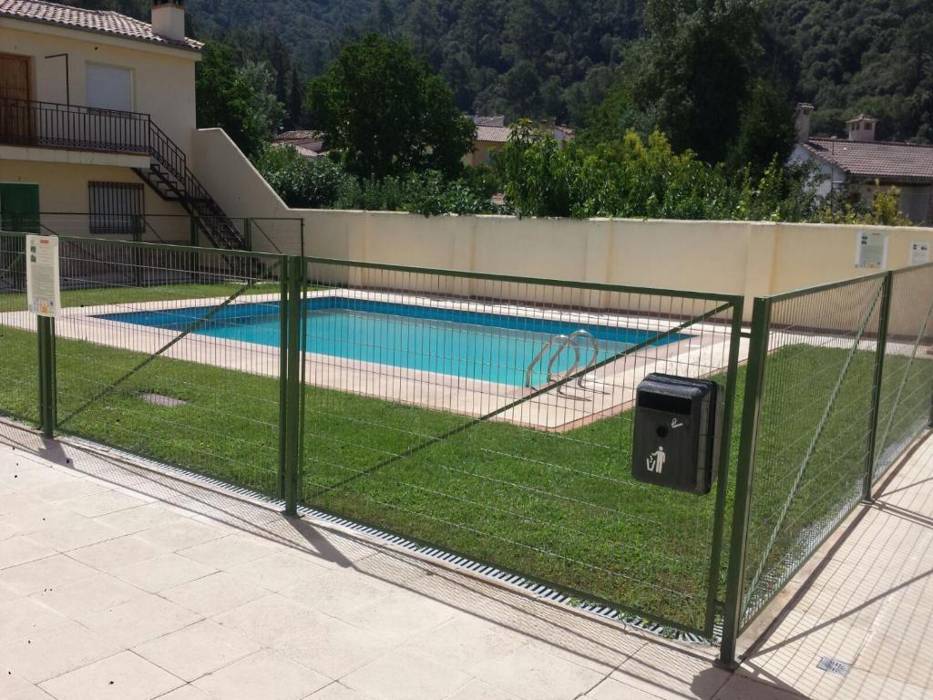 une clôture avec une piscine derrière dans l'établissement Los Olivos, à Arroyo Frío