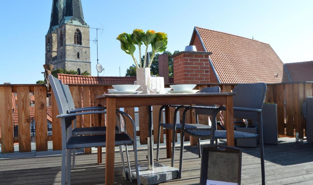 una mesa y sillas en una terraza con iglesia en Apartment anno 1720, en Quedlinburg