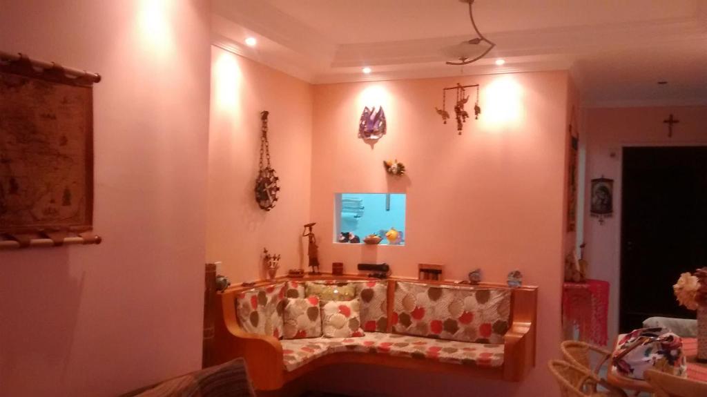 a living room with a couch on the wall at Apartamento Chile in Guarujá