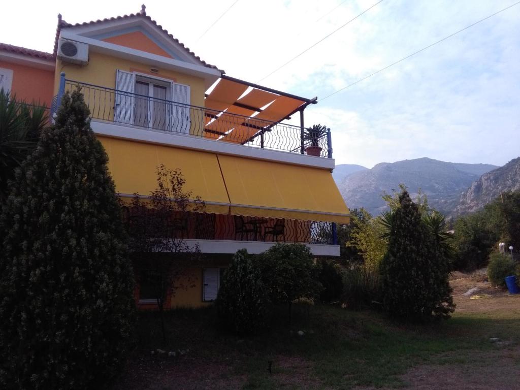 a house with a balcony and mountains in the background at M&L Studios in Valeriános