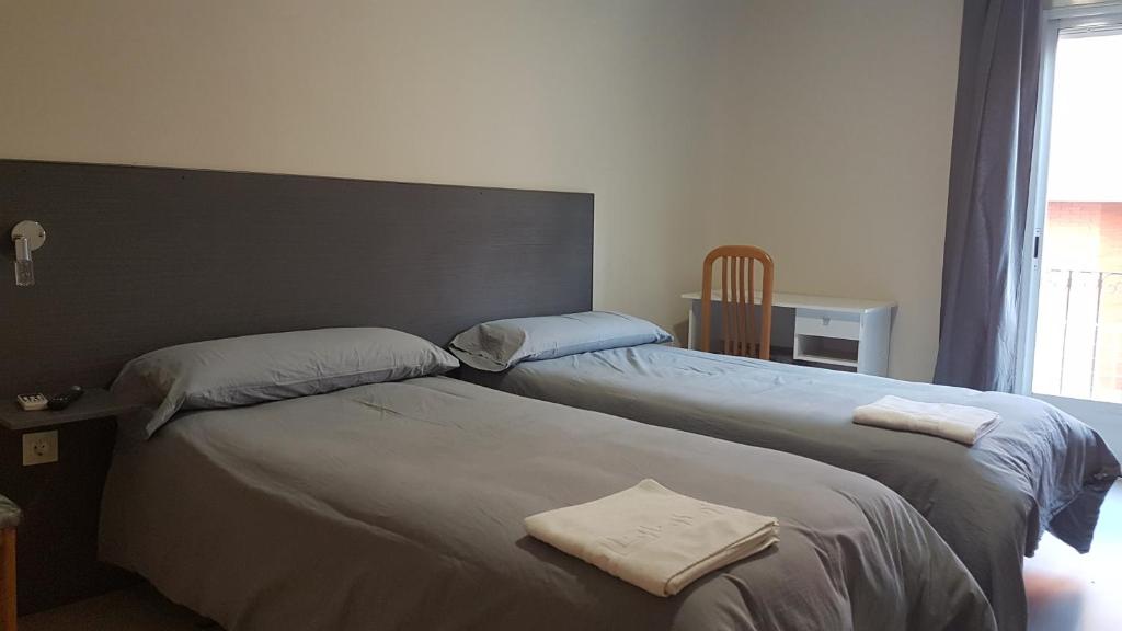 two beds sitting next to each other in a room at Hostal La Estación in Tarancón