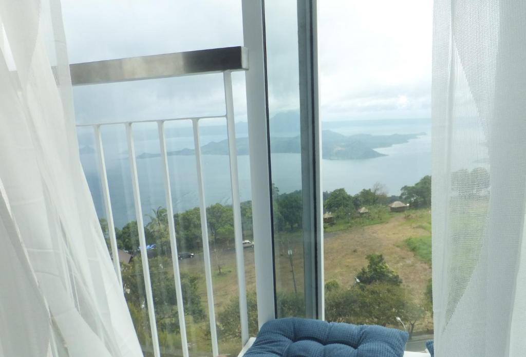 a room with a large window with a blue couch at Wind Residences Tower 4 in Tagaytay