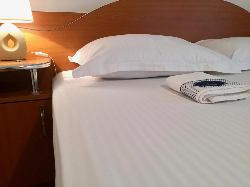 オラデアにあるG.EAG - Premium Apartmentのベッド(白いシーツ、枕付)、テーブル(ランプ付)