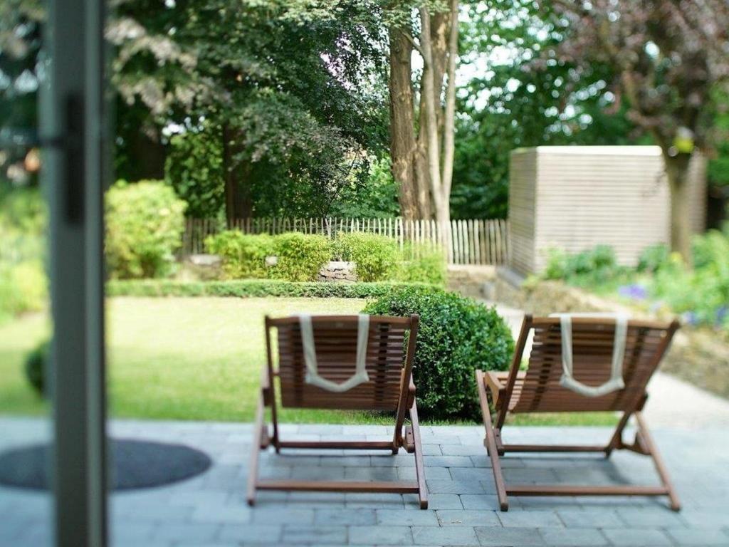 two chairs sitting on a patio in a garden at Gîte Au26 côté jardin-côté cour in Liège