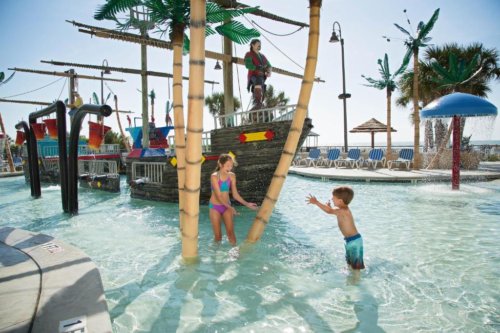 a boy and a girl playing in a water park at Captain's Quarters Resort in Myrtle Beach