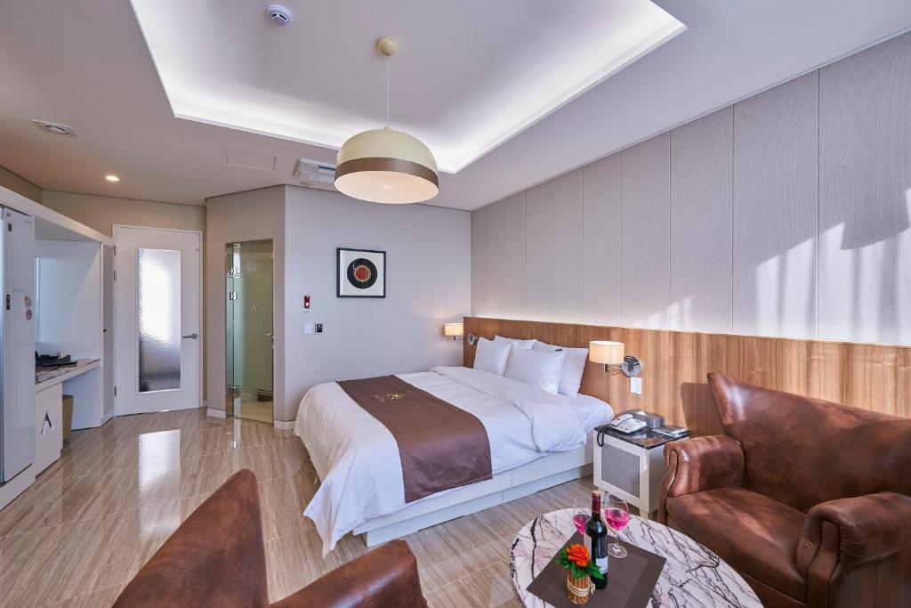 光州にあるクァンジュ オーラ ホテルのベッドとソファ付きのホテルルーム