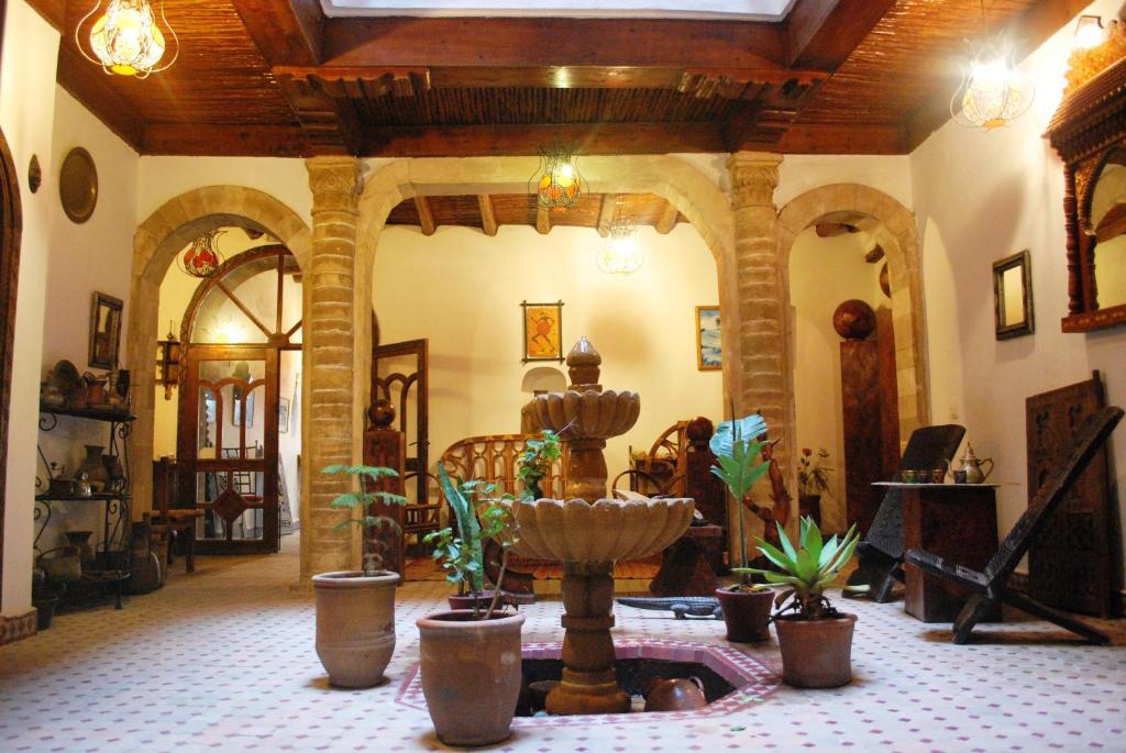 een woonkamer met een fontein en potplanten bij Caverne d'Ali Baba in Essaouira