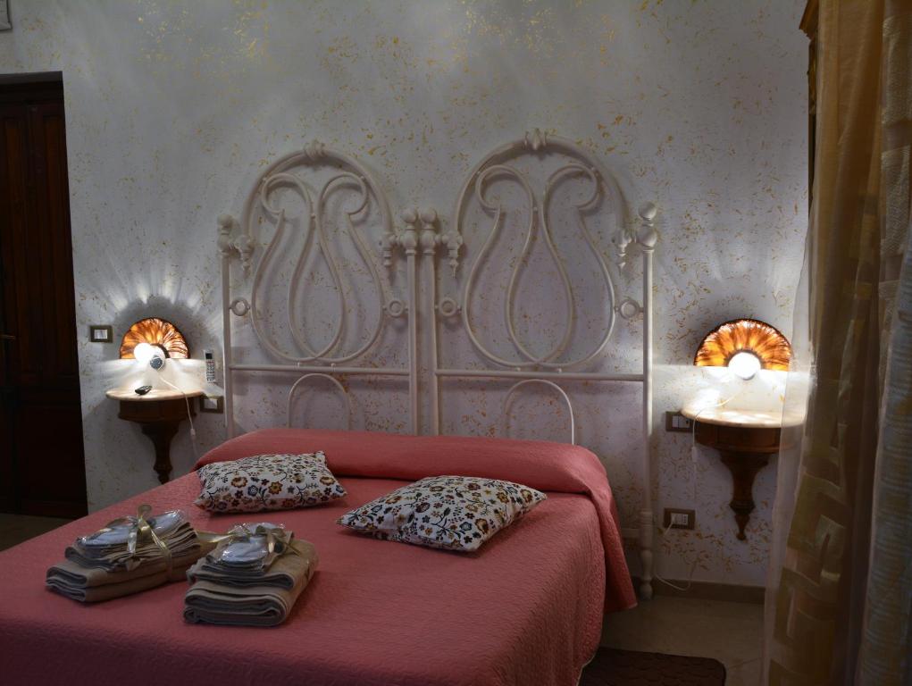 una camera da letto con un letto con una coperta rossa e due luci di Alle vecchie mura a Pistoia