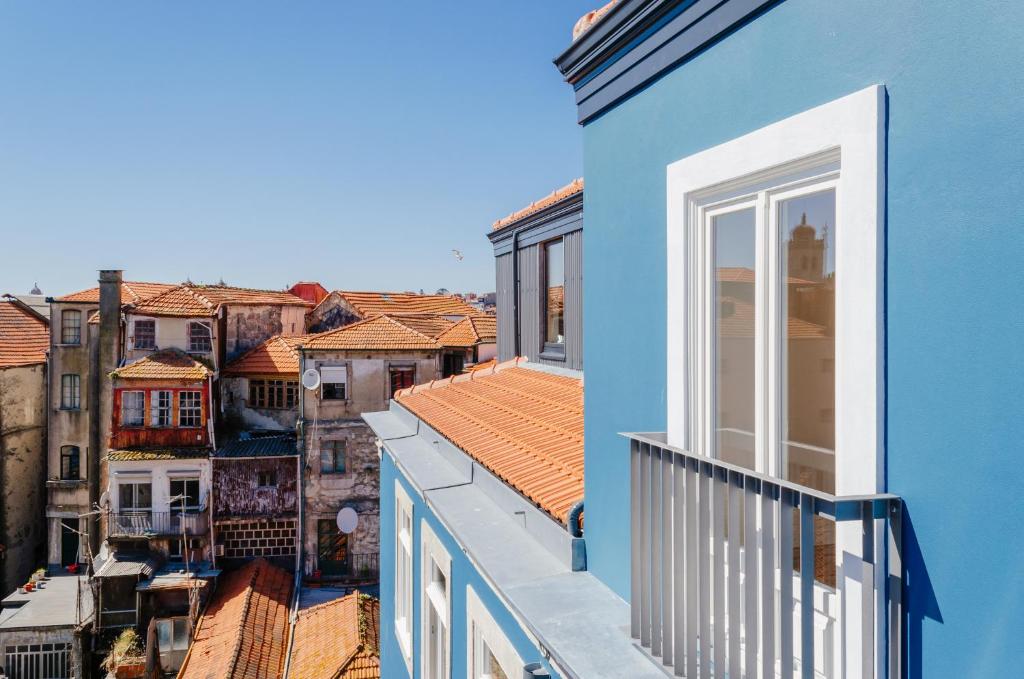 a blue building with a balcony and buildings at Amazing Penthouse Apartment in historic Porto in Porto